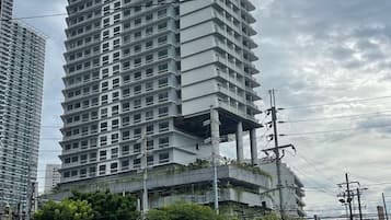 Ein mehrstöckiges Gebäude mit modernem architektonischen Design, mit Balkonen und einer flachen Dachfläche.
