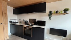 Une cuisine moderne avec des meubles noirs, une cuisinière en acier inoxydable et un four à micro-ondes.