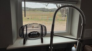 Une cuisine avec une fenêtre, un meuble à vin et un égouttoir à vaisselle.