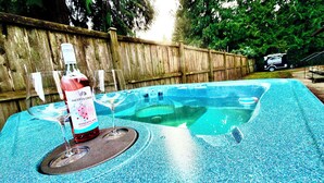 Een bubbelbad met een fles wijn en een glas.