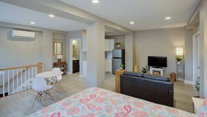 Un appartement moderne comprenant un salon, un coin repas, une cuisine et un balcon.