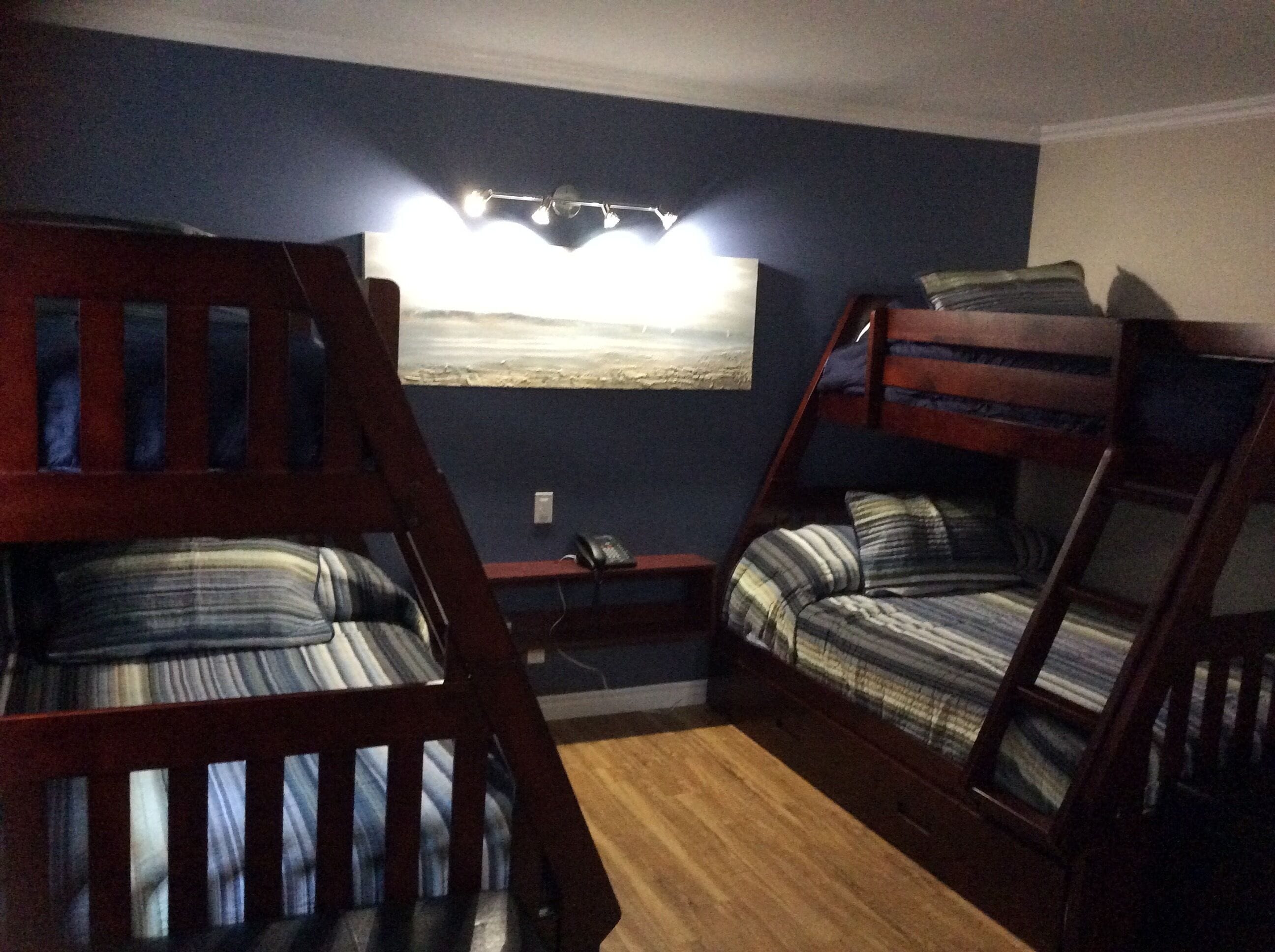 A room with bunk beds, a small table, and a wall-mounted light fixture.