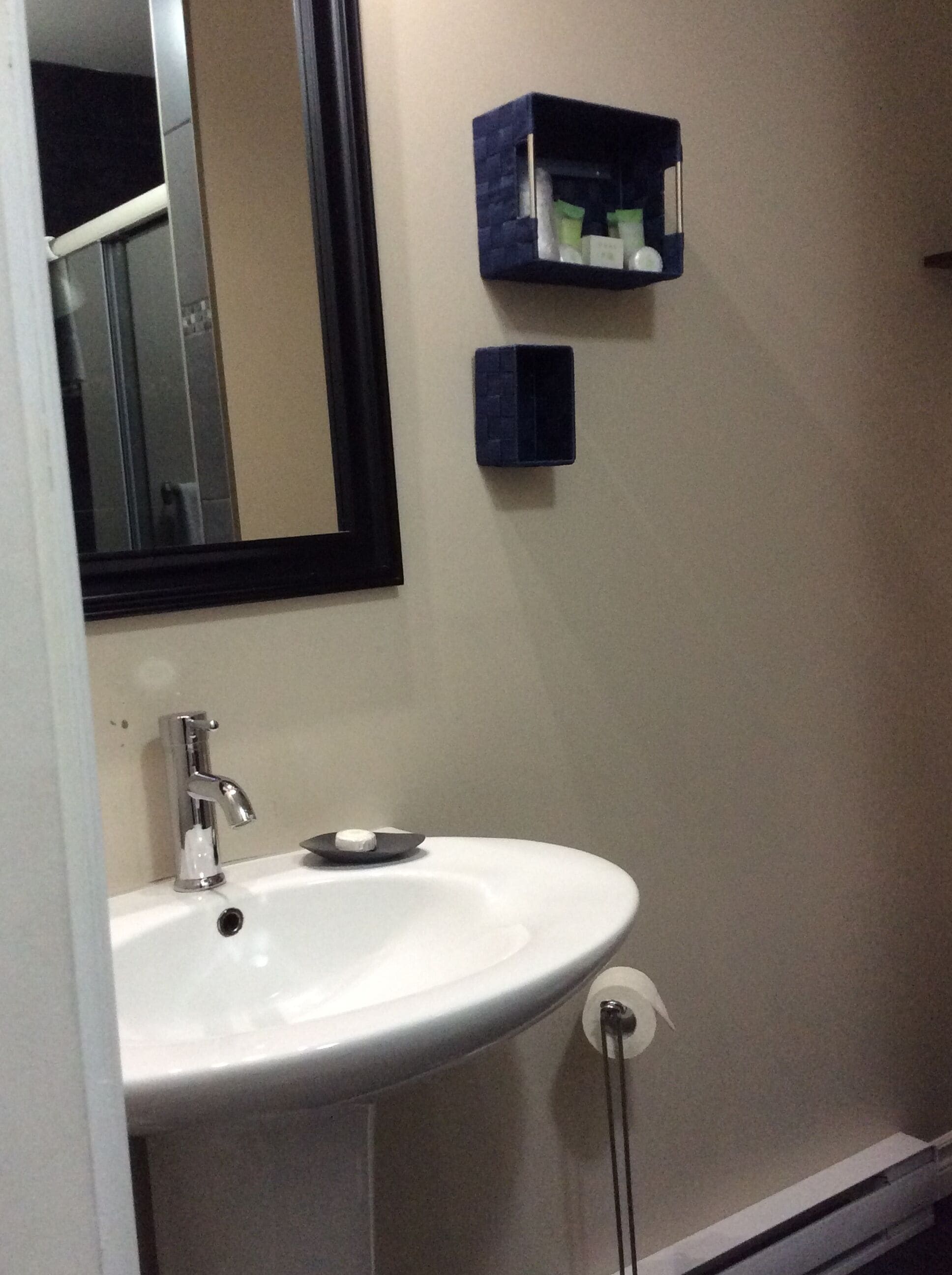 A bathroom with a white sink, a mirror, and a small blue medicine cabinet.