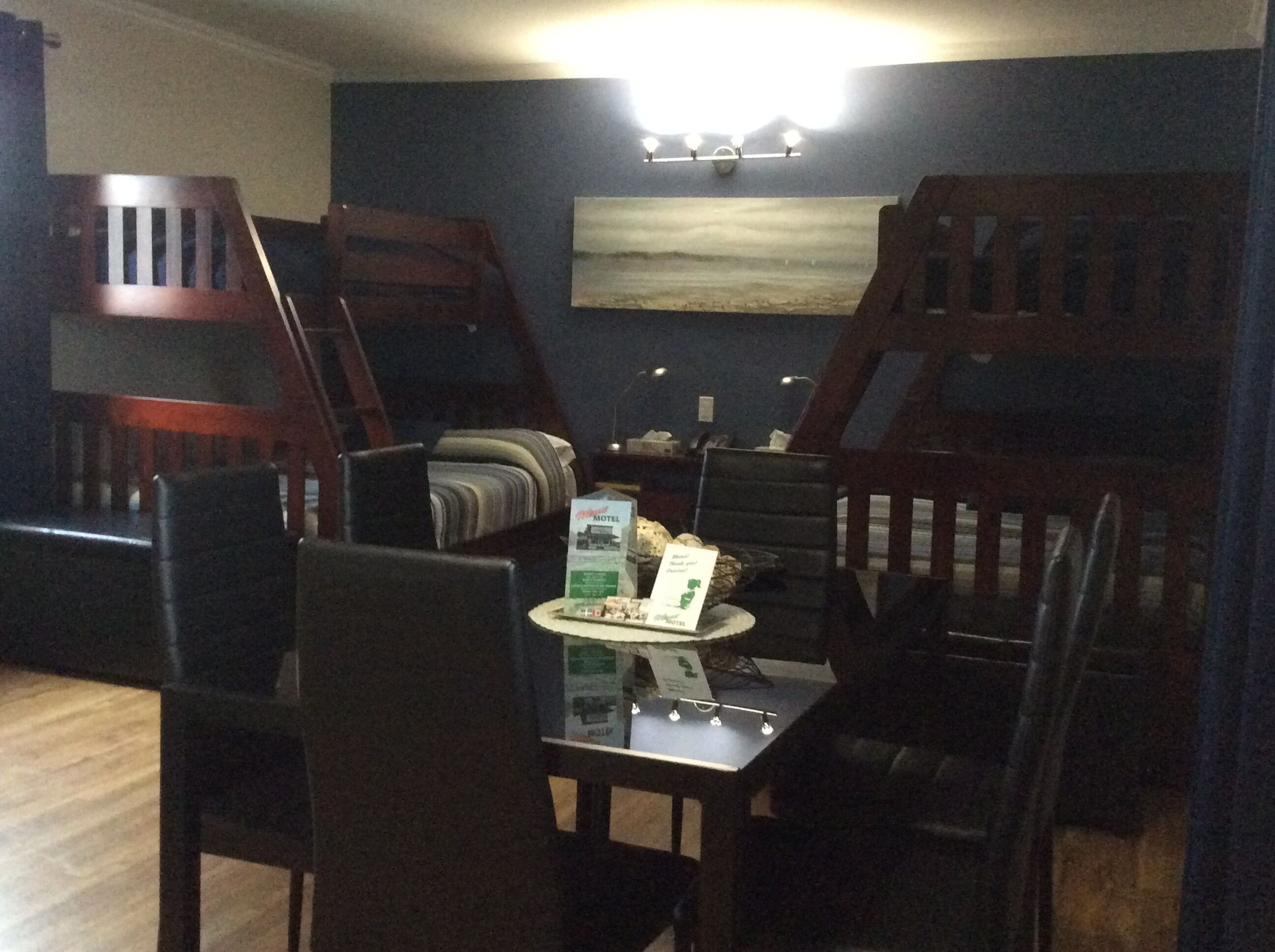 Un comedor con una mesa, sillas y una lámpara fijada a la pared.