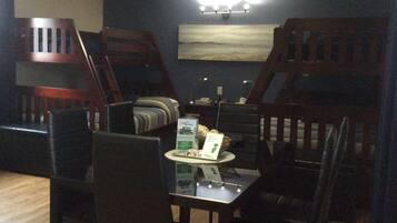 Un comedor con una mesa, sillas y una lámpara fijada a la pared.