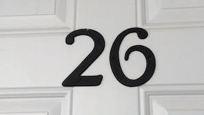 Une porte blanche avec le numéro « 26 » écrit en noir.