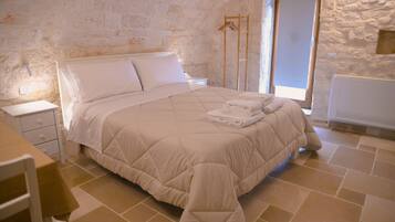 Una camera da letto con un letto, un comodino, una sedia e una finestra.
