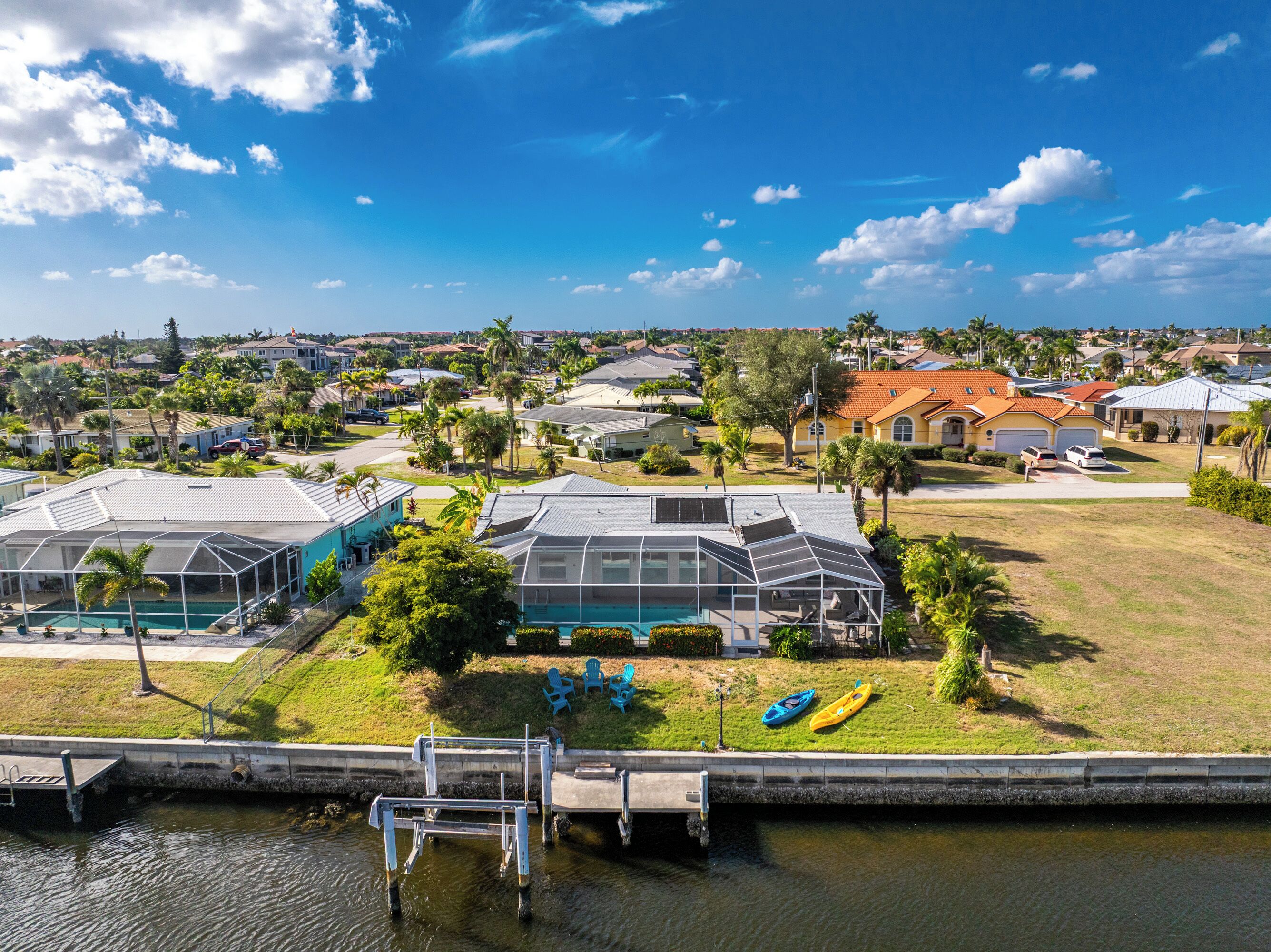A residential area with houses, a swimming pool, and a dock.