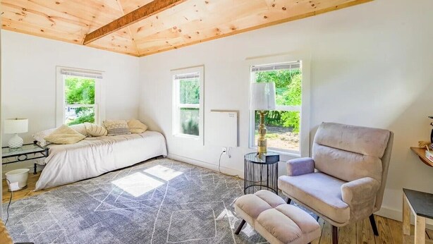 A room with a bed, a chair, a small table, and a window. - Amazing 2-bdrm apartment in quintessential coastal Friendship, Maine - 1st floor (Friendship)