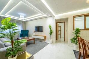 A modern living room with a sofa, coffee table, and potted plants. - Dar bensaid (Chefchaouen)
