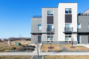 A modern multi-story building with a flat roof, large windows, and a mix of brick and concrete exterior.