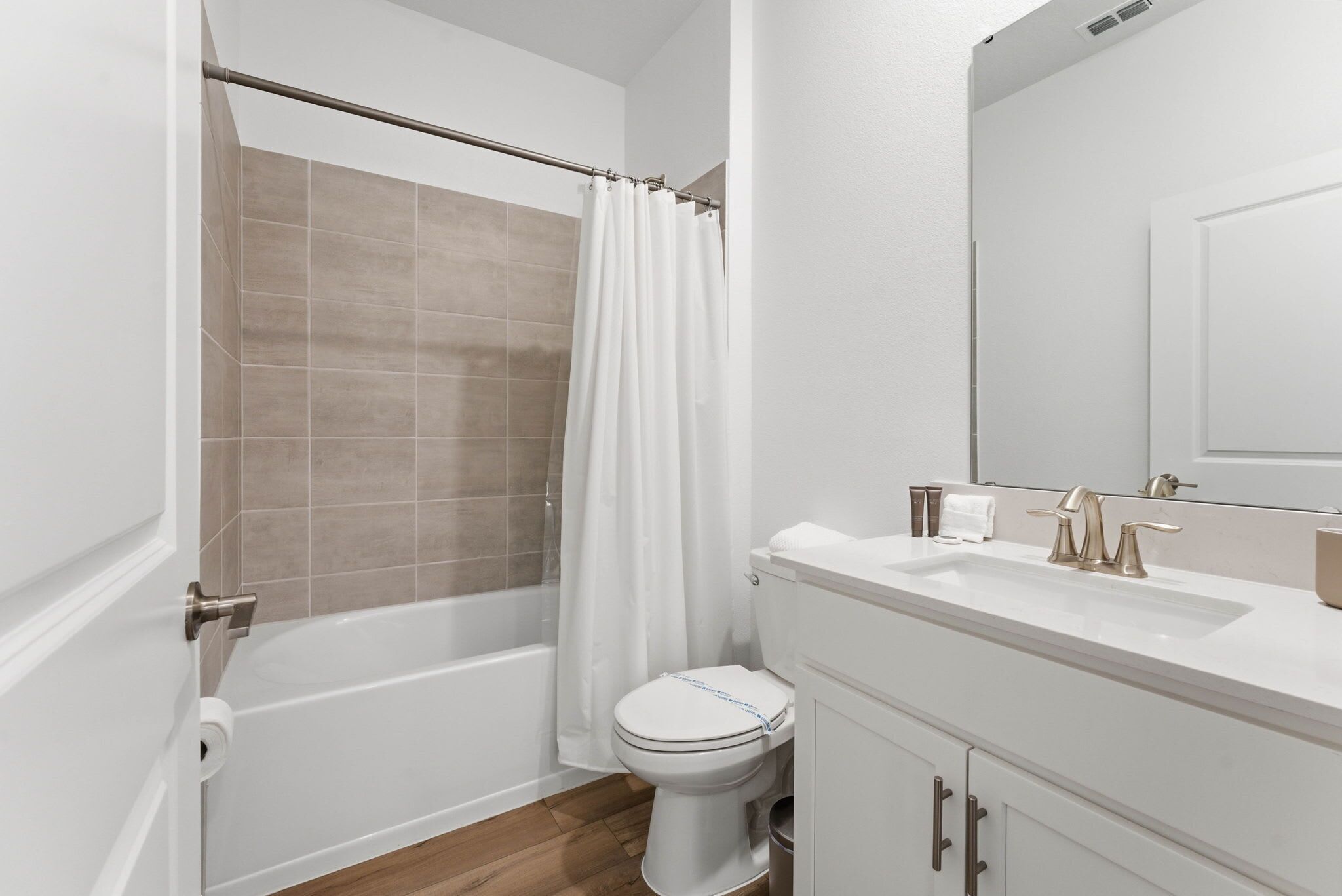 A bathroom with a bathtub, toilet, and sink.