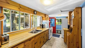 Una cocina con armarios de madera, un fregadero, una estufa y un refrigerador.