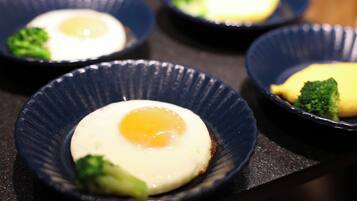A series of dark blue bowls containing a fried egg and broccoli.