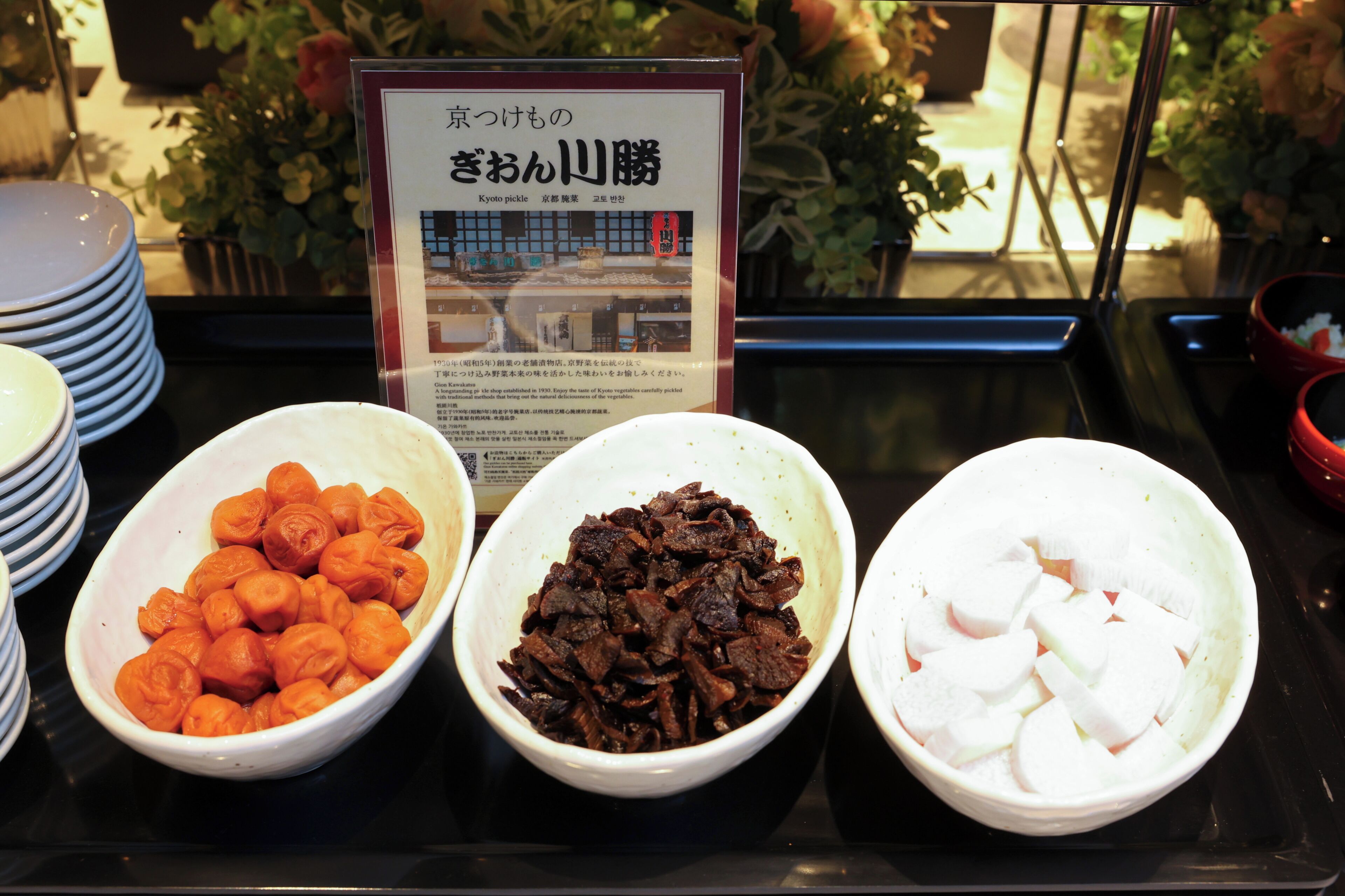 A buffet with three bowls of food.