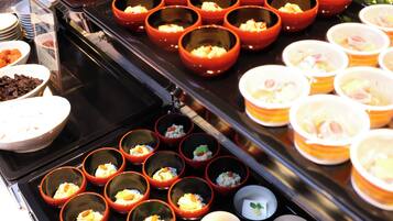 A buffet with various dishes in bowls and cups.
