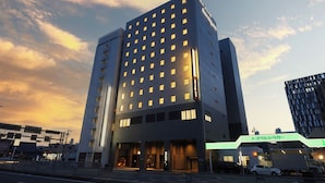 A modern hotel with a multi-story structure, large windows, and a prominent entrance. - Natural Hot Springs Higoromo no Yu Dormy Inn Yokkaichi (Yokkaichi)