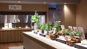 A buffet setup with various food items and decorative plants. - Natural Hot Springs Higoromo no Yu Dormy Inn Yokkaichi (Yokkaichi)