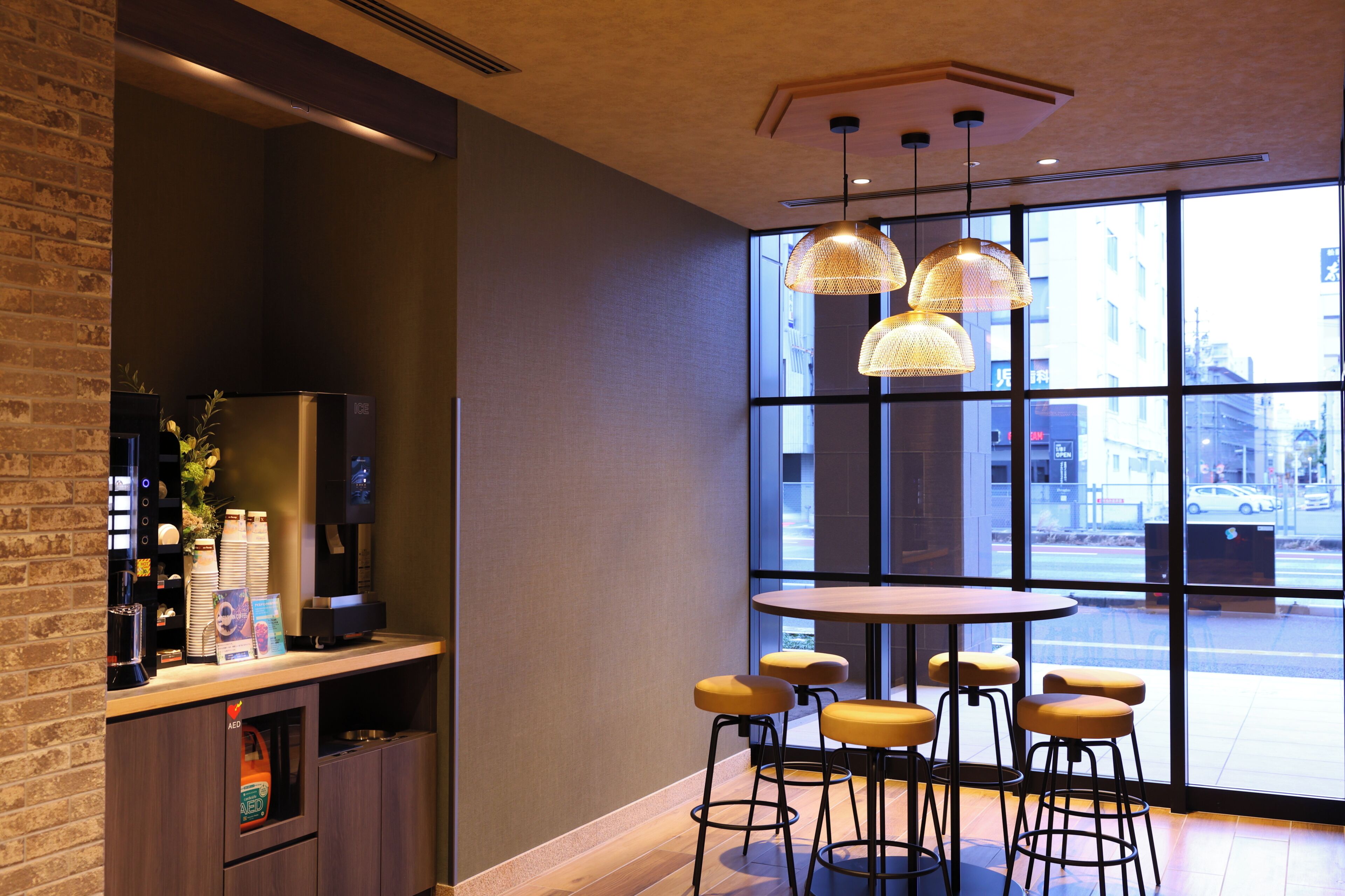 A modern bar area with a round table, bar stools, and pendant lighting.