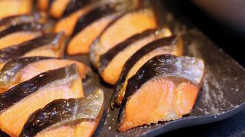 A tray of sliced salmon with a dark glaze.