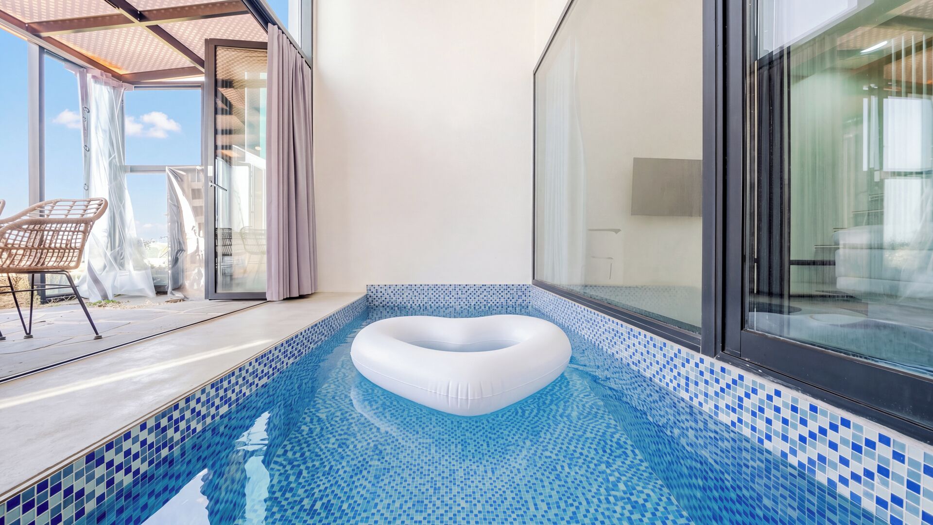 Ein moderner, überdachter Pool mit Blick auf den Himmel durch große Fenster.