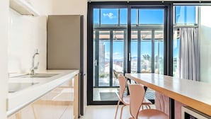 Una cocina moderna con un gran ventanal, un comedor con sillas y vistas a la ciudad.