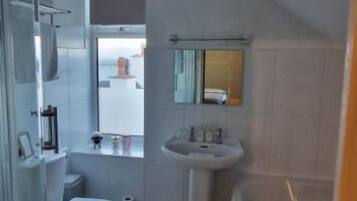 A bathroom with a shower, toilet, sink, and bathtub.