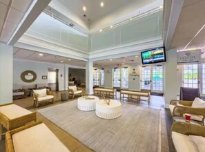 A spacious lobby with high ceilings, comfortable seating areas, and a large television screen. - Poolside Near Disney 1st Floor *no resort fees* (Davenport)