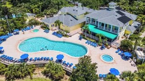 Ein Resort mit großem Pool, mehreren Gästezimmern und Strandabschnitt.