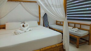 Ein Zimmer mit einem großen Bett, einem kleineren Bett und einer Bank. Über dem größeren Bett befindet sich ein Baldachin.