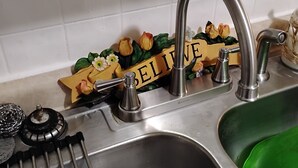 A kitchen sink with a stainless steel faucet and a green basin. - Awesome 3-bedroom house with AC in delightful downtown Augusta Georgia (Augusta)