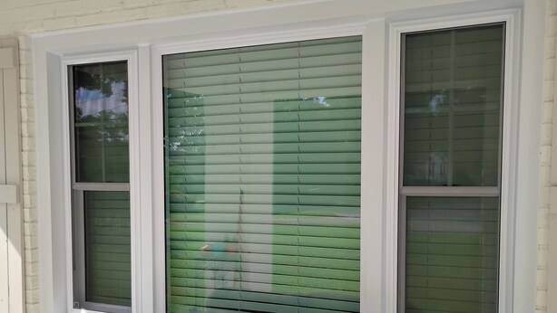 A bench with a floral cushion in front of a white brick wall with two windows. - Awesome 3-bedroom house with AC in delightful downtown Augusta Georgia (Augusta)