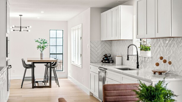 A modern kitchen with white cabinets, a herringbone backsplash, and a central island. - Fully Renovated Furnished Home in Hurst – Perfect for Mid-Term Stays (Hurst)