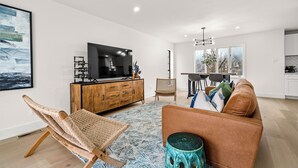 A modern living room with a television, sofa, and dining area. - Fully Renovated Furnished Home in Hurst – Perfect for Mid-Term Stays (Hurst)