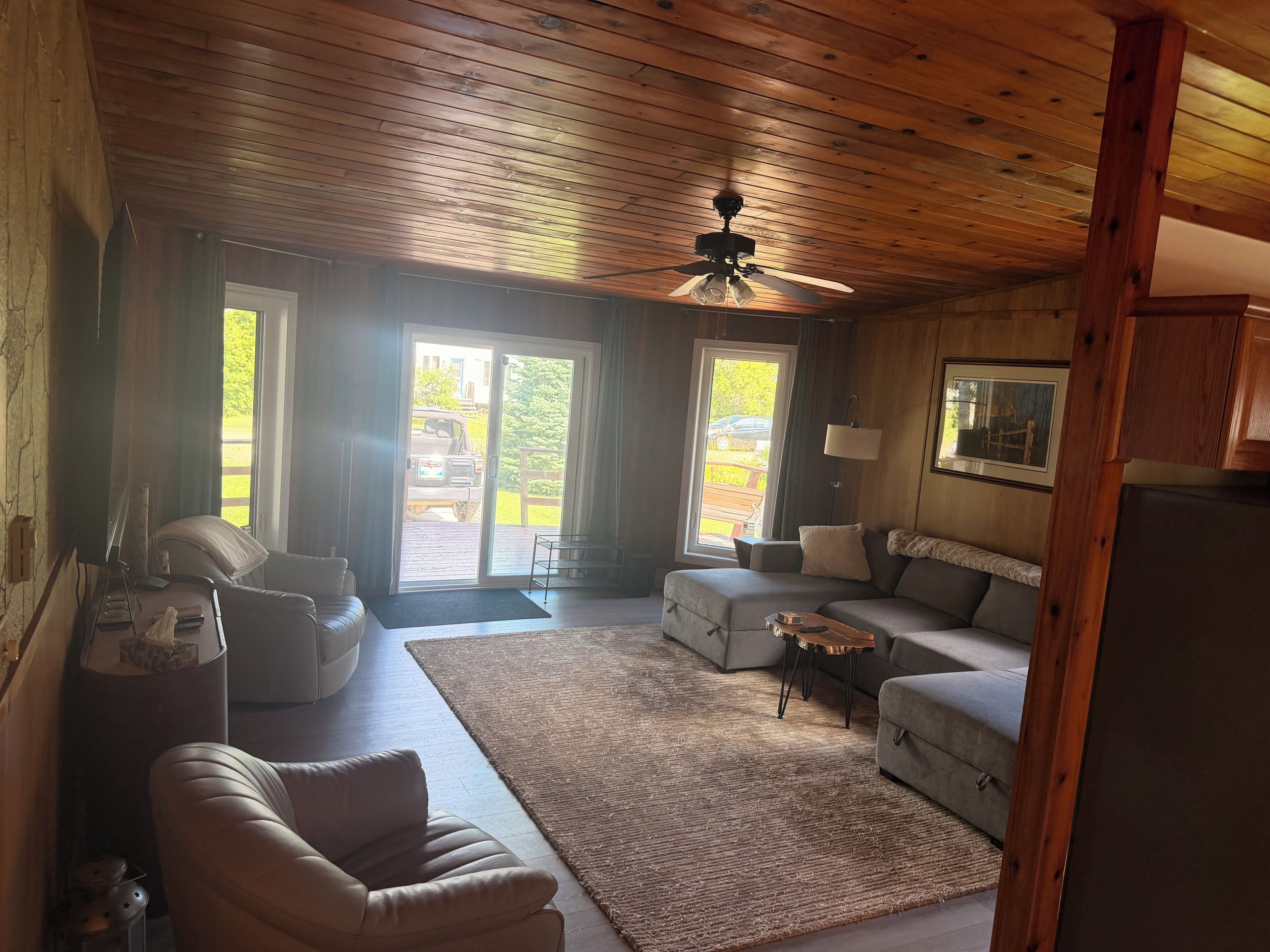 A cozy living room with a ceiling fan, a sofa, a coffee table, and a rug.