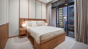 Ein modernes Hotelzimmer mit einem großen Bett, einem Holz-Kopfteil, Nachttischlampen und Blick auf ein Gebäude durch eine Glastür.