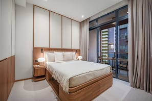 A modern hotel room with a large bed, wooden headboard, bedside lamps, and a view of a building through a glass door.
