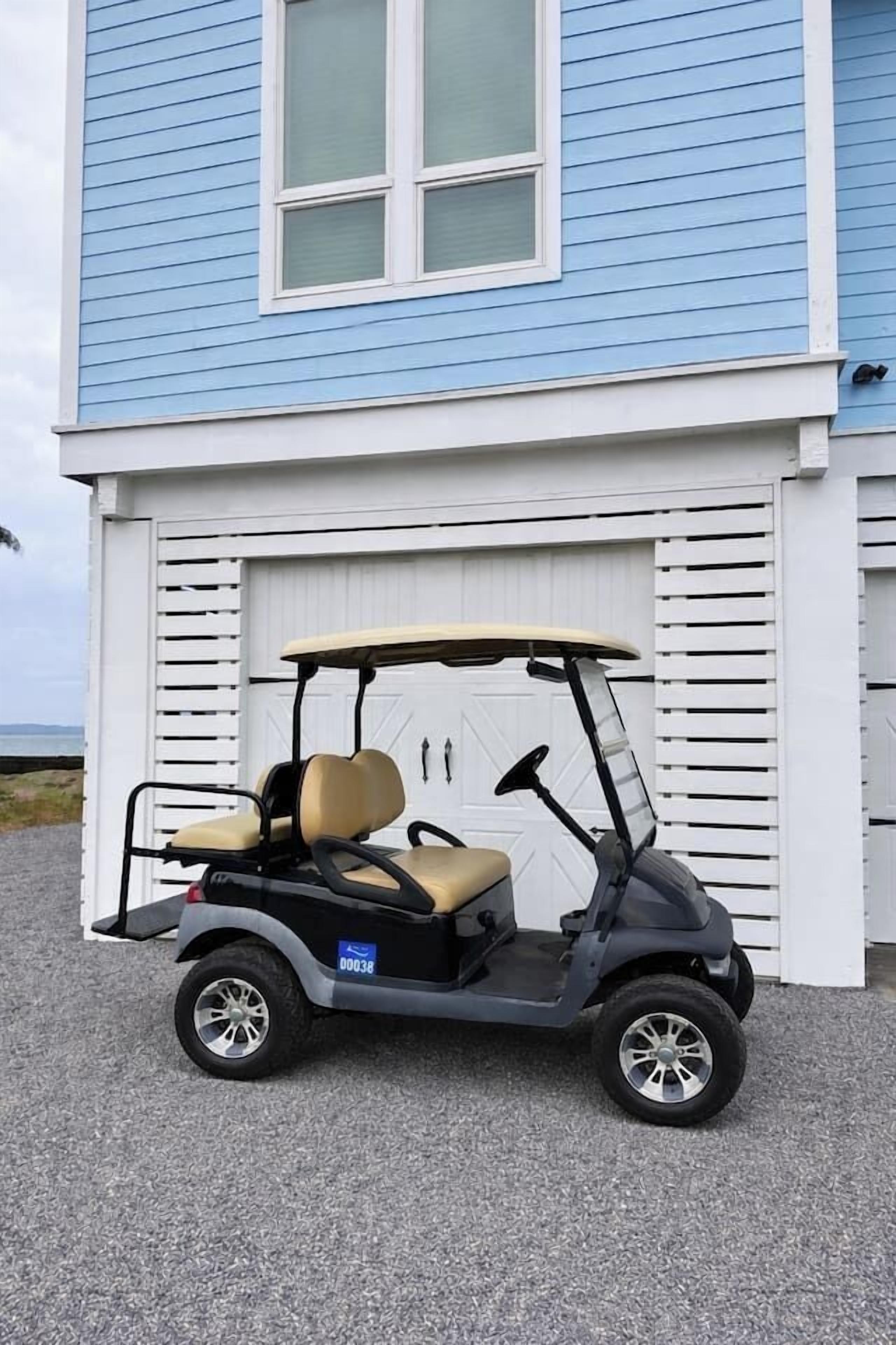 Un carrello da golf parcheggiato davanti a una casa con un garage.
