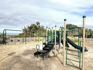 A playground with a slide, climbing structures, and a swing set.