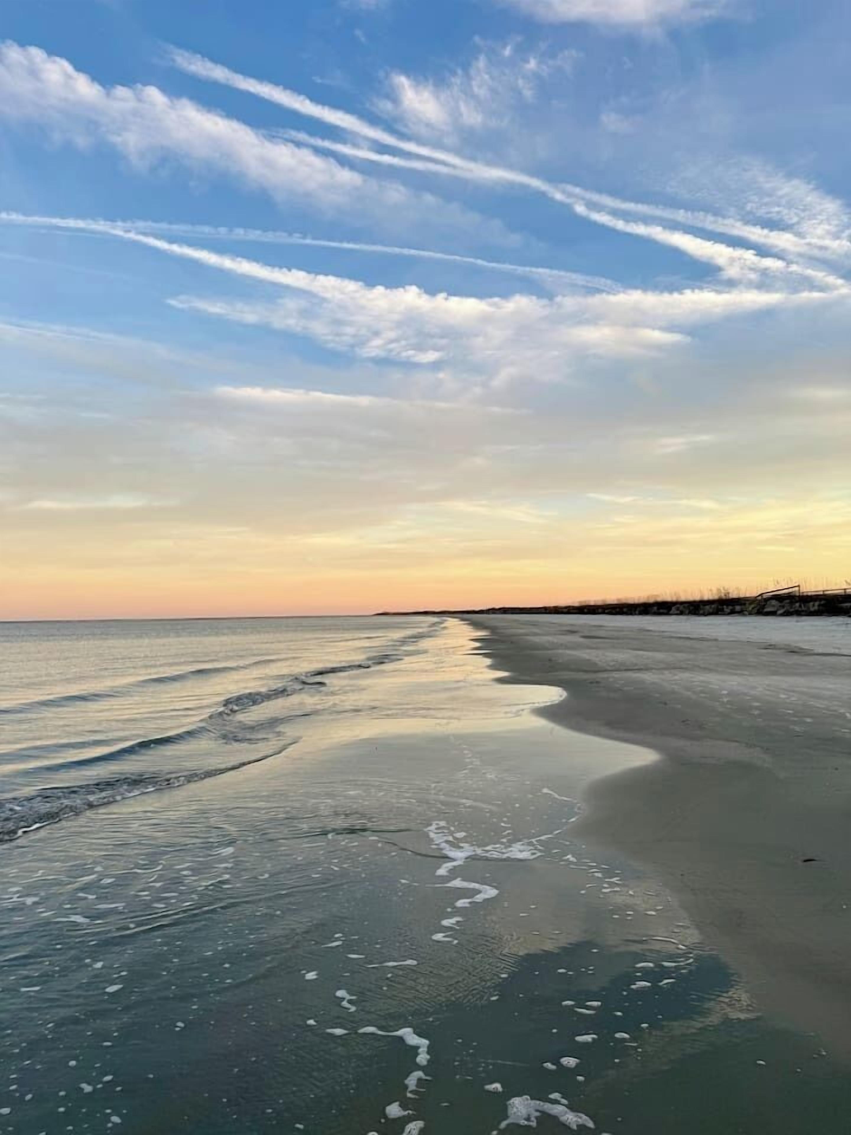 A beach with a clear sky and a calm sea.