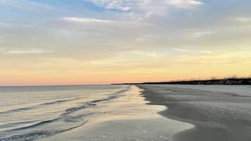 Een strand met een heldere lucht en een rustige zee.