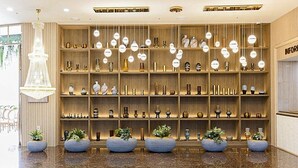 A modern interior with wooden shelves displaying various decorative items and hanging spherical lights.
