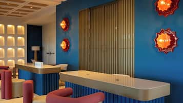 A hotel reception area with a blue wall, a large window, and a reception desk.