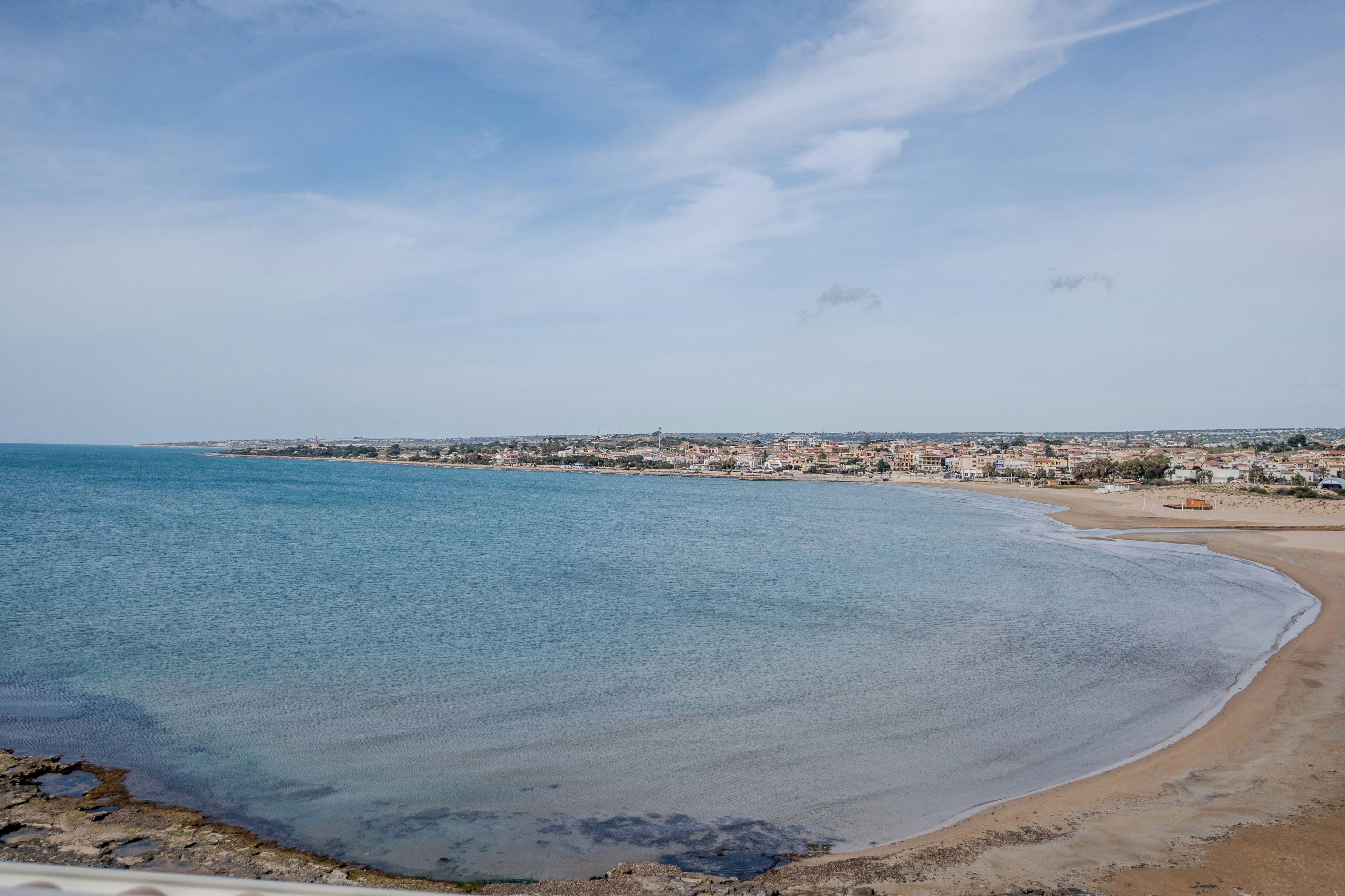 A coastal town with a beach and a clear sky.