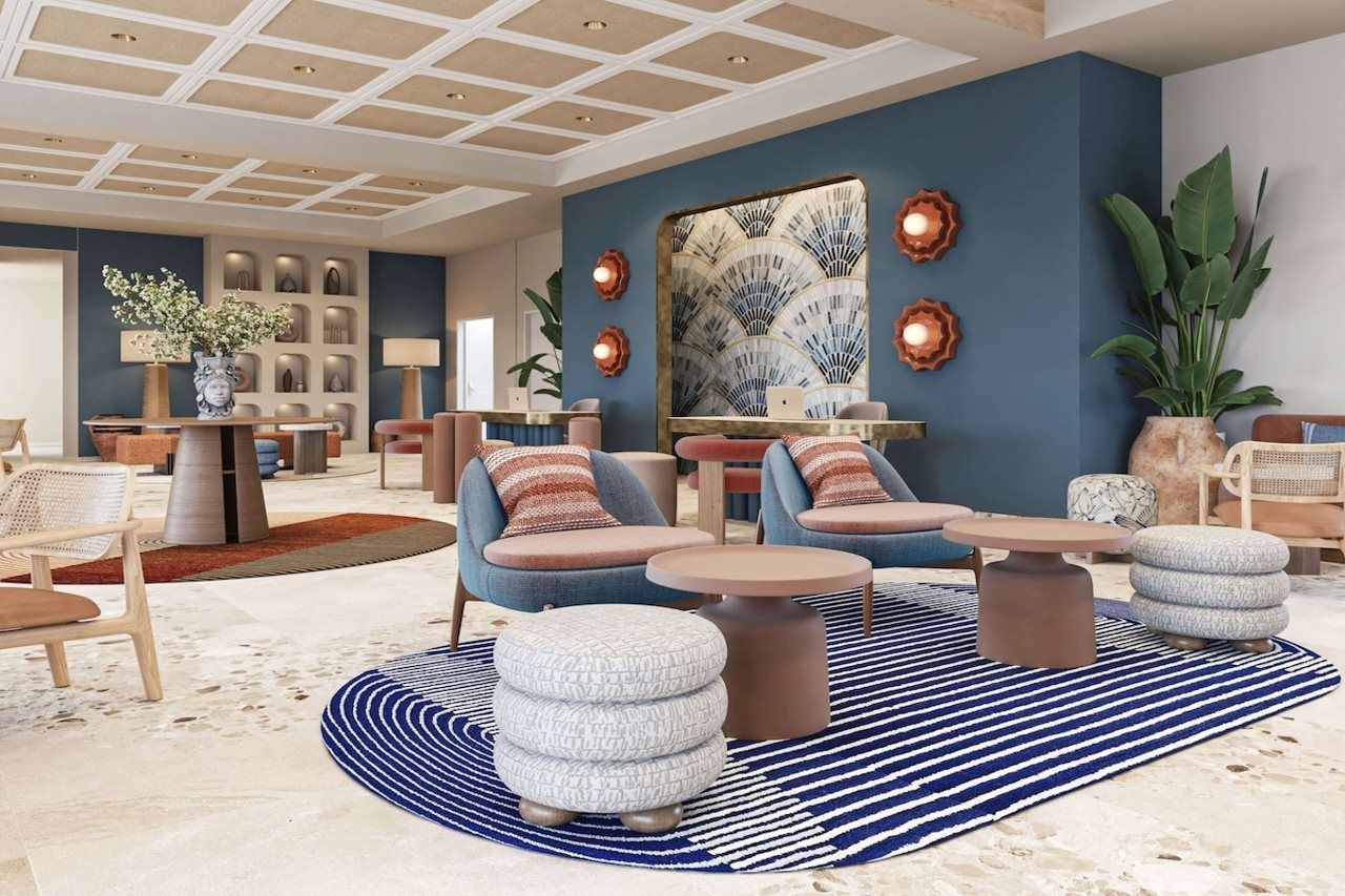 A modern lounge area with seating, a large mirror, and decorative wall sconces.