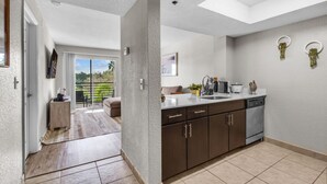 A modern kitchen with a built-in dishwasher, a large window, and a balcony with a view of greenery. - FTL 1BR Near Beach | Pool + Free Parking (Fort Lauderdale)