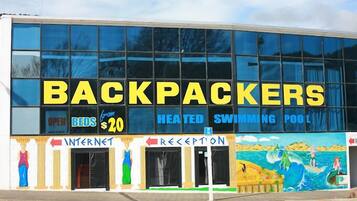 Een gebouw met een bord waarop 'BACKPACKERS' en 'OPEN BEDDEN $20' staat.