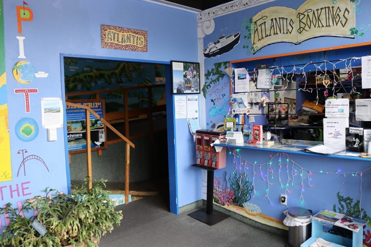 A room with a blue wall, a reception desk, and a door leading to another room.