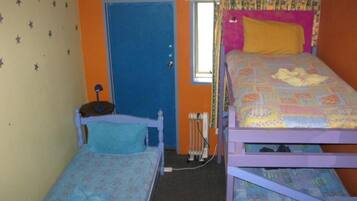 Una habitación con dos literas, una puerta, un radiador y una ventana.