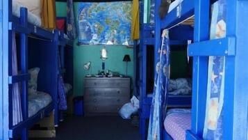 Habitación con literas, un aparador y un mapa en la pared.
